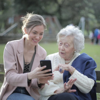 Younger female helping an older female with a tablet