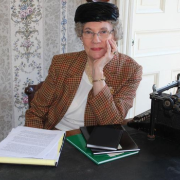 Chris Brookes dressed as Agatha Christie surrounded by journals and a typewriter