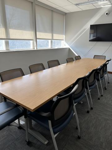 Conference room table setup for 12 with a TV