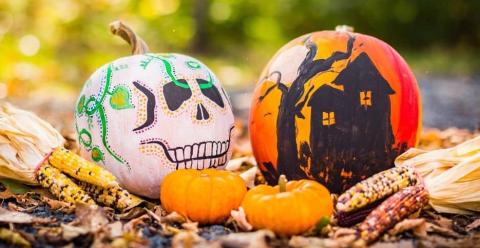 pumpkins decorated as a skull and haunted house