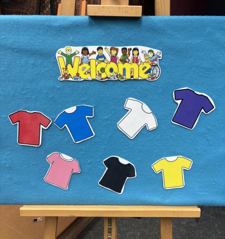 Flannel board with "Welcome" and shirts in different colors.