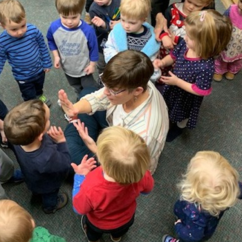 Ms. Maria on floor with children