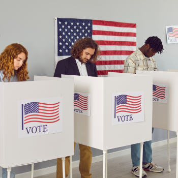 Individuals in voting booths