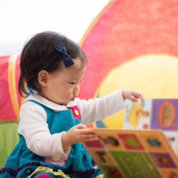 child looking at board book