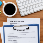 Resume and job application with computer keyboard in the background