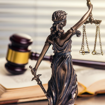 Gavel and Lady Justice with law books in the background.