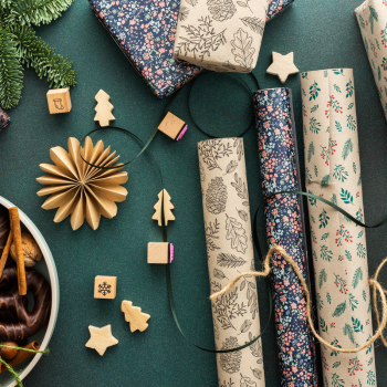 Rolls of holiday wrapping paper on a green background